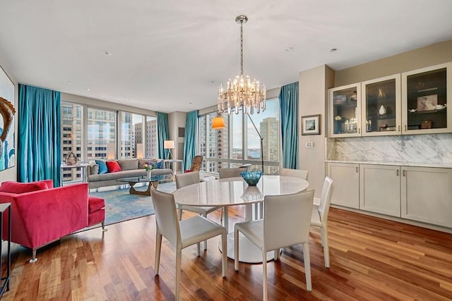 dining area with an inviting chandelier, hardwood / wood-style floors, and expansive windows