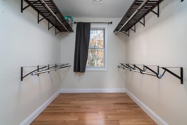 walk in closet with hardwood / wood-style floors