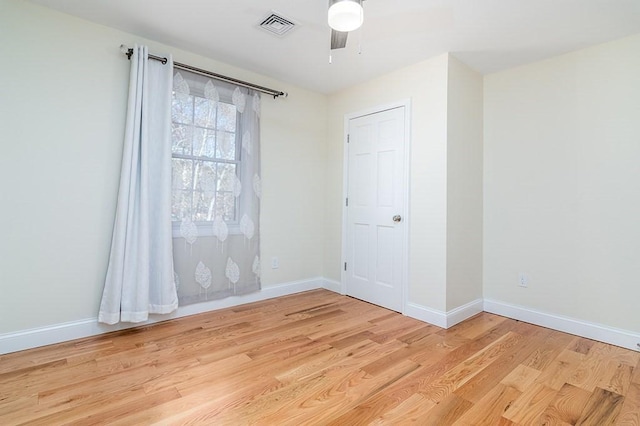 empty room with ceiling fan and light hardwood / wood-style flooring