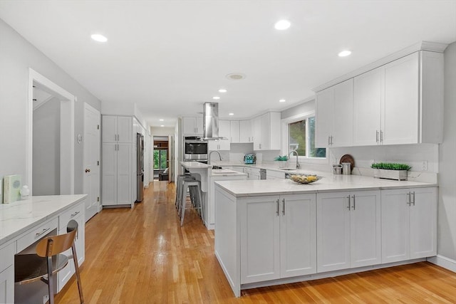 14 Preservation Way, Westford, MA 01886 - kitchen with stainless steel appliances, a peninsula, white cabinets, recessed lighting, and light wood finished floors
