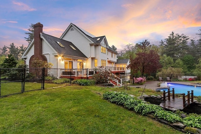 14 Preservation Way, Westford, MA 01886 - back of house at dusk featuring a wooden deck, a gate, stairs, and a chimney