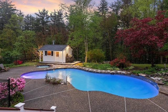 14 Preservation Way, Westford, MA 01886 - pool at dusk with an outbuilding, fence, a patio area, and an in-ground hot tub
