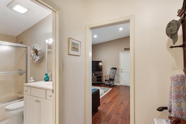 425 Main St Unit 8B, Hudson, MA 01749 - bathroom with vanity, wood finished floors, toilet, vaulted ceiling, and combined bath / shower with glass door