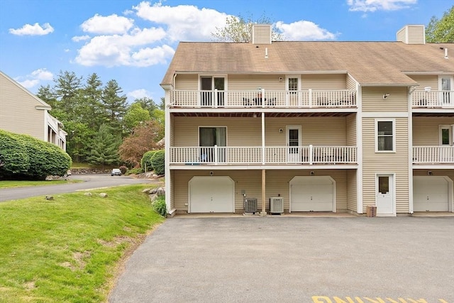425 Main St Unit 8B, Hudson, MA 01749 - rear view of house featuring central AC, a garage, a chimney, and asphalt driveway