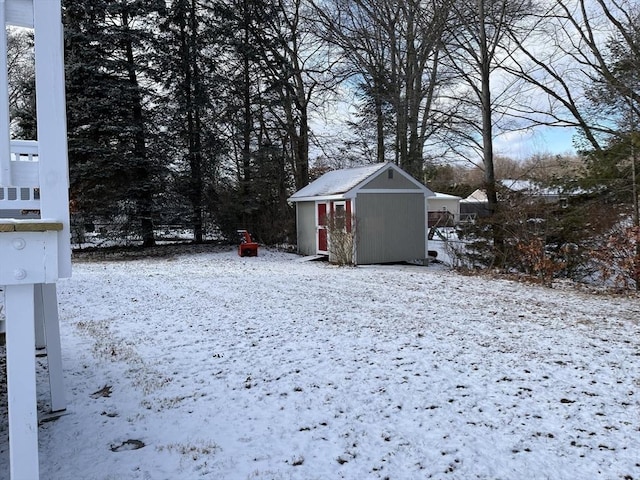 snowy yard with a storage shed