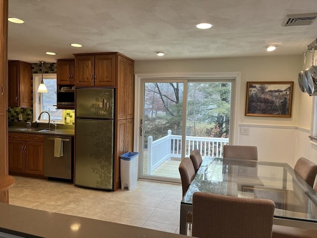 kitchen featuring dishwasher, refrigerator, sink, decorative light fixtures, and light tile patterned flooring