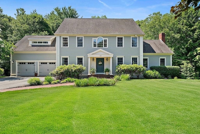 148 Old Schoolhouse Ln, Hanover, MA 02339 - colonial-style house featuring a front lawn, asphalt driveway, an attached garage, and a chimney