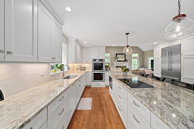 148 Old Schoolhouse Ln, Hanover, MA 02339 - kitchen with stainless steel appliances, light wood finished floors, white cabinets, tasteful backsplash, and recessed lighting