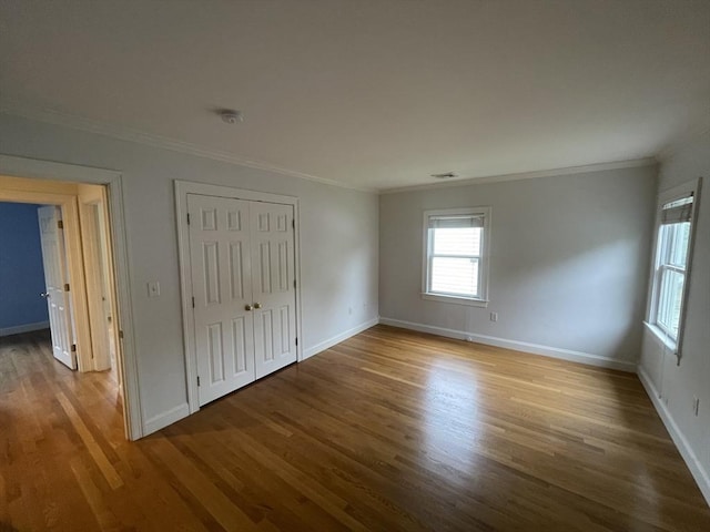 58 Oak St, Wellesley, MA 02482 - unfurnished bedroom featuring crown molding, wood finished floors, baseboards, and a closet