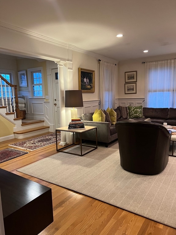 living room with light hardwood / wood-style floors and decorative columns