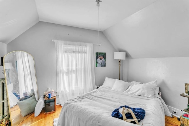 bedroom with hardwood / wood-style floors and vaulted ceiling