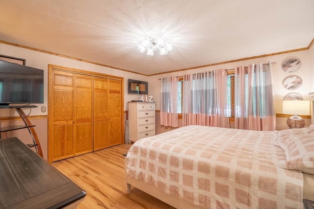 bedroom featuring light wood-style floors, a closet, and crown molding