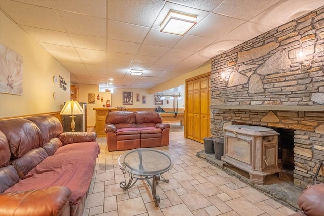 living area with bar, a wood stove, and wainscoting
