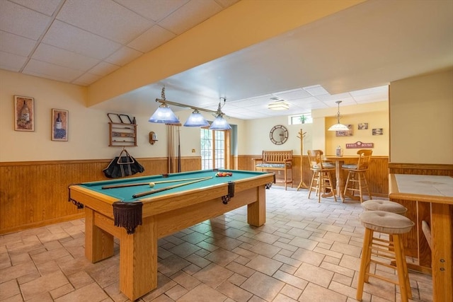 rec room with wainscoting, a bar, billiards, and wooden walls