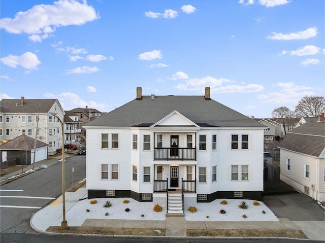 view of front of house with a residential view and a balcony