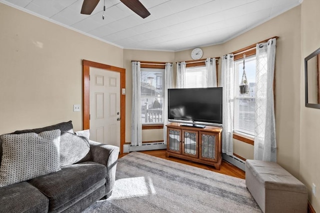 living area featuring a baseboard radiator, ornamental molding, ceiling fan, and wood finished floors