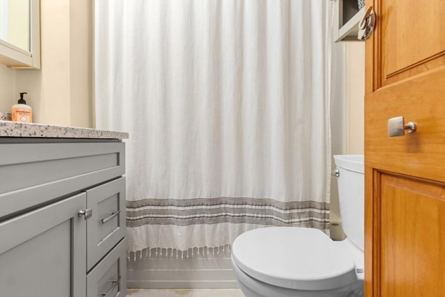 bathroom featuring a shower with shower curtain, vanity, and toilet