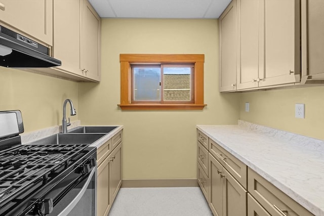 kitchen with under cabinet range hood, a sink, baseboards, light countertops, and stainless steel gas range