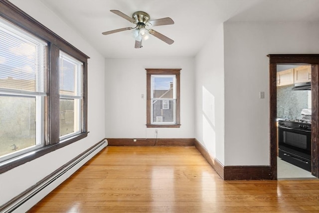 unfurnished room featuring light wood-style flooring, baseboards, and baseboard heating