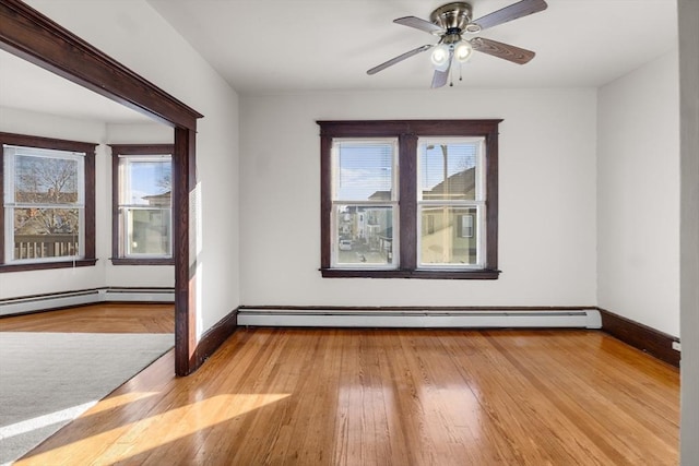 unfurnished room with baseboards, a baseboard heating unit, and light wood-style floors