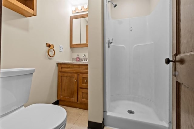 full bathroom with a stall shower, vanity, toilet, and tile patterned floors