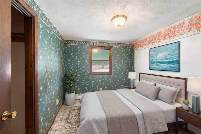 bedroom with wallpapered walls and a textured ceiling