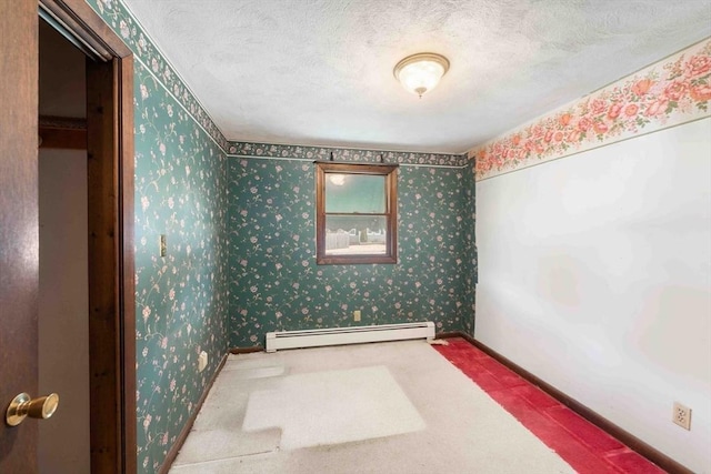 carpeted spare room featuring a baseboard heating unit, baseboards, a textured ceiling, and wallpapered walls