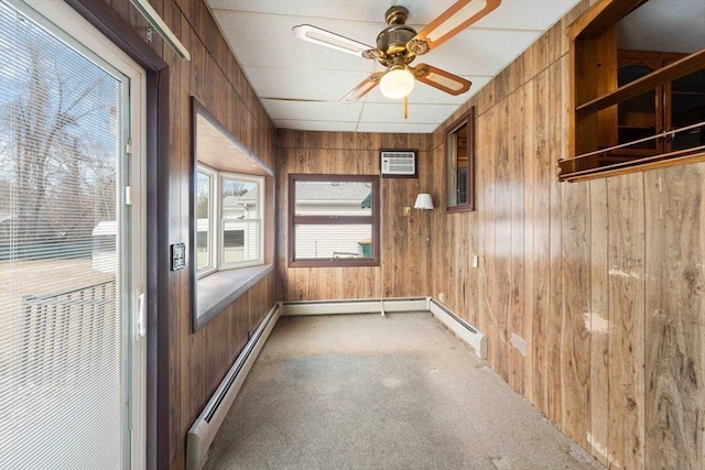 unfurnished sunroom featuring an AC wall unit, a baseboard heating unit, and a ceiling fan