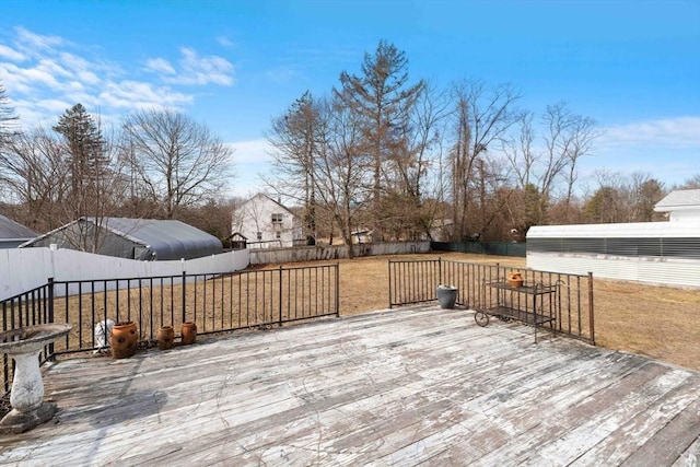 wooden terrace with a lawn and a fenced backyard