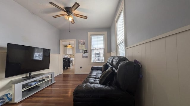 living room with dark wood-type flooring and ceiling fan