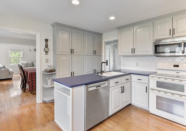 27 N Brigham Hill Rd, Grafton, MA 01536 - kitchen featuring stainless steel appliances, dark countertops, light wood-type flooring, tasteful backsplash, and recessed lighting