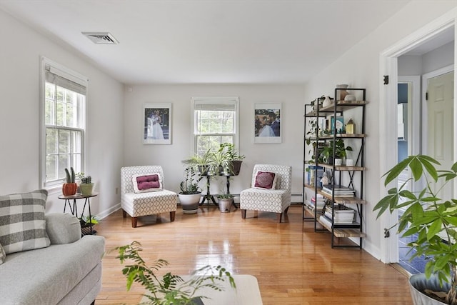 27 N Brigham Hill Rd, Grafton, MA 01536 - living area with plenty of natural light, light wood-type flooring, and a baseboard radiator