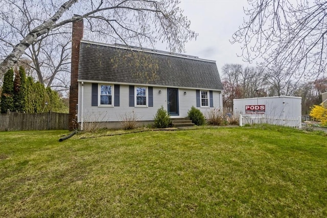 colonial inspired home with a front lawn, roof with shingles, fence, and a chimney