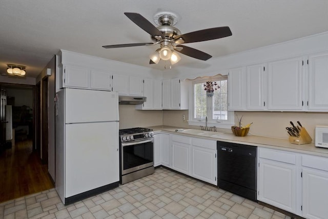kitchen with white appliances, light countertops, white cabinetry, under cabinet range hood, and a sink