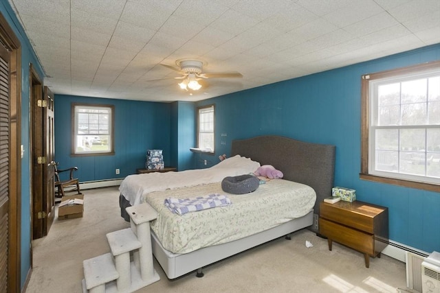 carpeted bedroom featuring ceiling fan, baseboard heating, and a baseboard heating unit