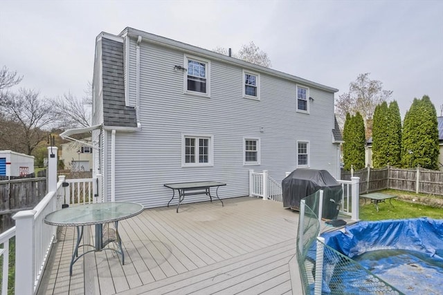 back of property with a wooden deck and a fenced backyard