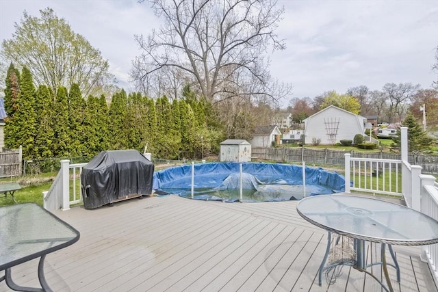 view of swimming pool featuring a fenced in pool, a fenced backyard, grilling area, and a deck