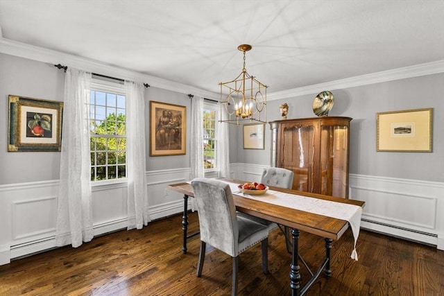 dining area with a baseboard radiator, wood finished floors, a chandelier, wainscoting, and crown molding