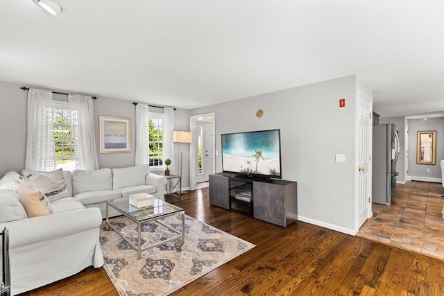 living area with baseboards and wood finished floors