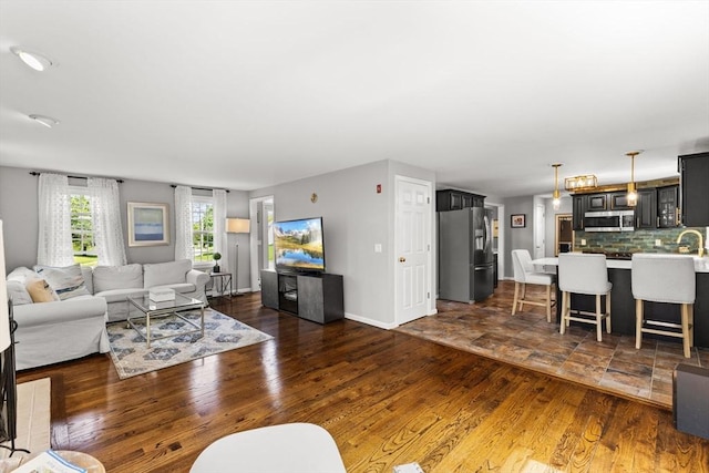 living area with baseboards and dark wood-type flooring