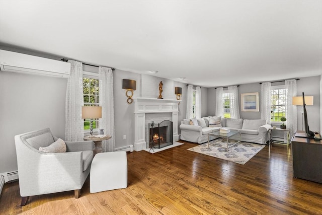 living room with an AC wall unit, a baseboard heating unit, a fireplace with flush hearth, and wood finished floors