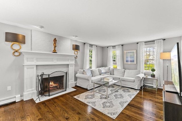 living area with a fireplace with flush hearth, plenty of natural light, and dark wood-type flooring