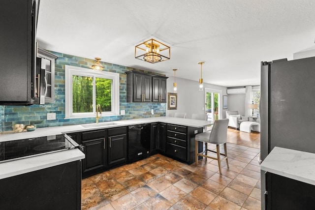 kitchen with dishwasher, freestanding refrigerator, a sink, open floor plan, and dark cabinetry