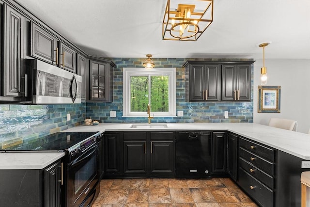 kitchen with black appliances, a sink, a peninsula, backsplash, and dark cabinets