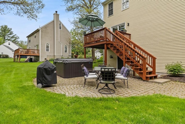 rear view of property with a hot tub, a deck, a patio area, a lawn, and stairs