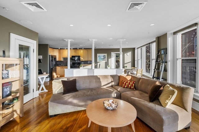 living room with hardwood / wood-style floors and ornate columns