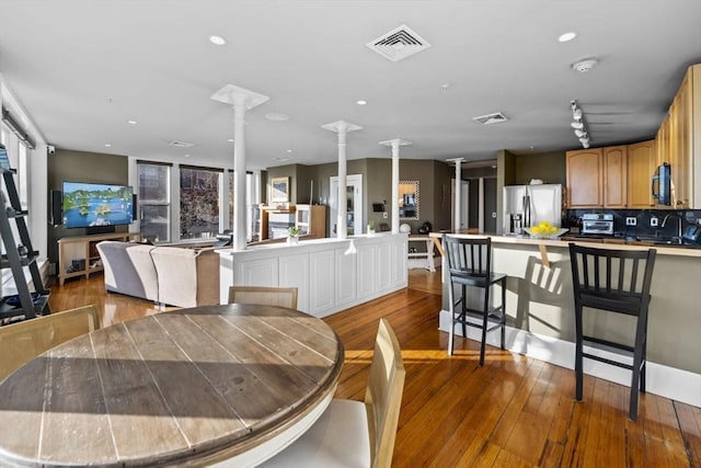 dining room featuring light hardwood / wood-style flooring, ornate columns, and sink