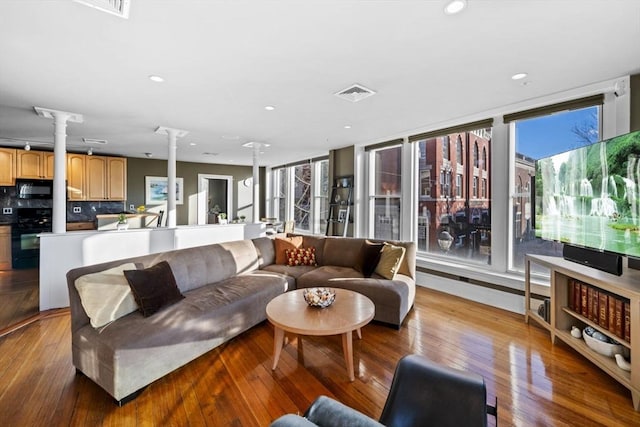 living room featuring light wood-type flooring and ornate columns