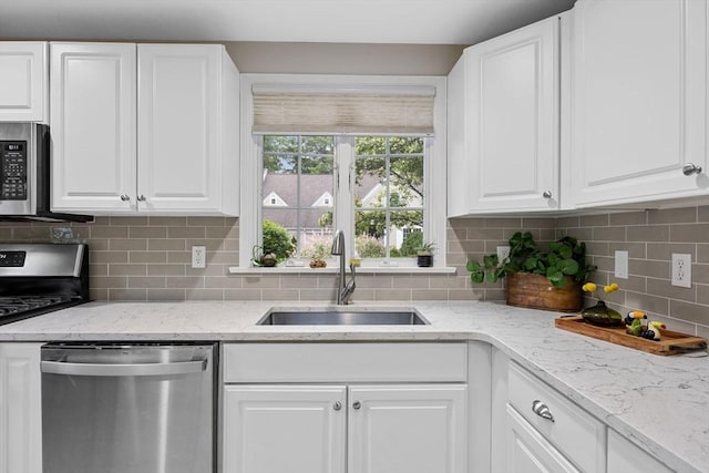 2 Darby Pt Unit 2, Mashpee, MA 02649 - kitchen with stainless steel appliances, white cabinetry, tasteful backsplash, and light stone counters