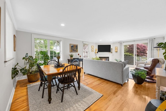 2 Darby Pt Unit 2, Mashpee, MA 02649 - dining area with light wood-style flooring, healthy amount of natural light, a glass covered fireplace, crown molding, and recessed lighting